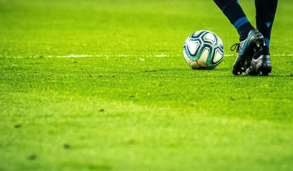Un hombre jugando al fútbol en un campo.